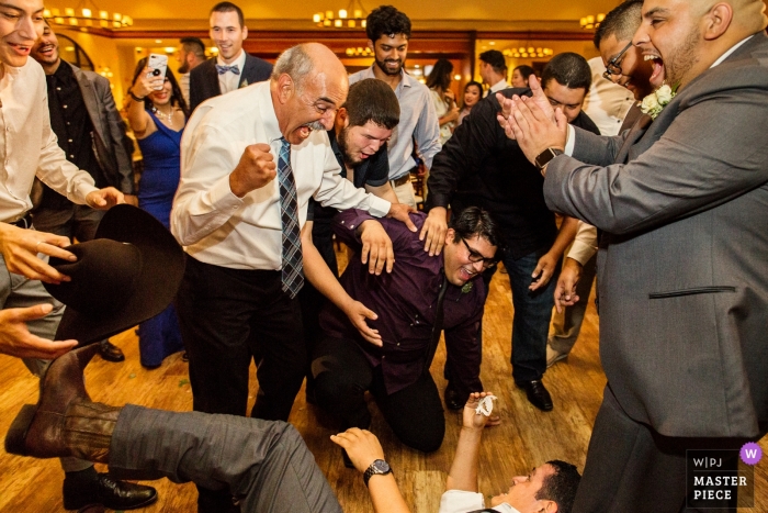 Photo by: <a href="https://www.wpja.com/contests/2018-v15/best-wedding-photographers/2318016">Chris Shum - Sunnyvale California</a> Garre Vineyard and Winery, Livermore wedding photo from the garter toss with a man down on the dance floor.