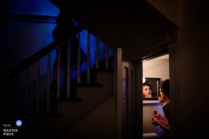 Foto di: <a href="https://www.wpja.com/contests/2018-v15/best-wedding-photographers/2318071"> Jacob Hannah - Lincoln Vermont </a> Lenox, fotografia matrimoni MA della sposa prepara il trucco in un bagno con un piccolo specchio