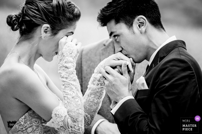 Foto di: <a href="https://www.wpja.com/contests/2018-v15/best-wedding-photographers/2318766"> Johnny Shryock - Arlington Virginia </a> Shenandoah Woods, Luray, VA fotografia di matrimonio dello sposo che bacia la mano della sposa durante questa cerimonia all'aperto.
