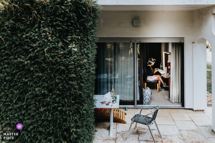 Fotojornalismo de casamento no Landhotel Waldhaus - noiva se preparando perto de uma parede de Hera
