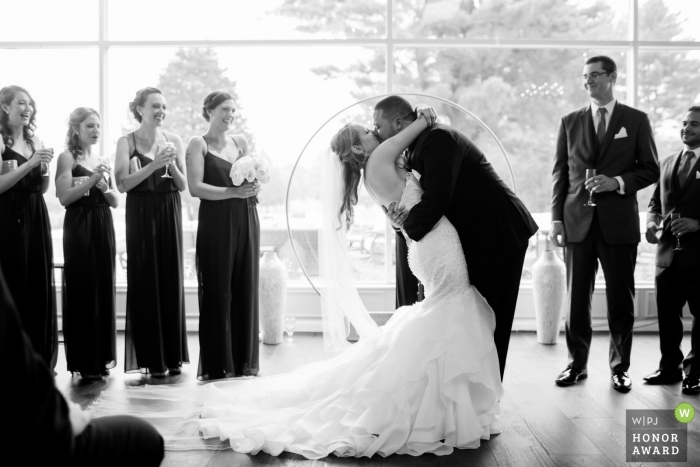 Photo by: <a href="https://www.wpja.com/contests/2018-v16-photography-competition/best-wedding-photographers/2323836">Kevin Trimmer - Providence Rhode Island</a> Backlit ceremony Picture of a couple kissing and dipping, by a top Providence wedding photographer