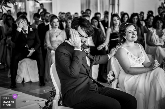 Foto di: <a href="https://www.wpja.com/contests/2018-v16/best-wedding-photographers/2324441"> Matteo Lomonte - Gioia del Colle Bari </a> Foto di nozze in Puglia uno sposo che si pulisce il viso durante la cerimonia con la sua sposa seduta accanto a lui