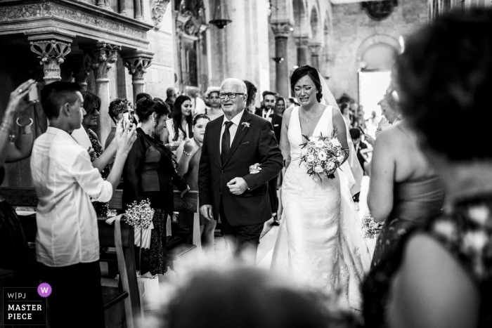 Foto di: <a href="https://www.wpja.com/contests/2018-v16/best-wedding-photographers/2324466"> Matteo Lomonte - Gioia del Colle Bari </a> Immagine di una sposa che diventa emotiva mentre entra in chiesa con suo padre, da un top fotografo di matrimoni in Puglia