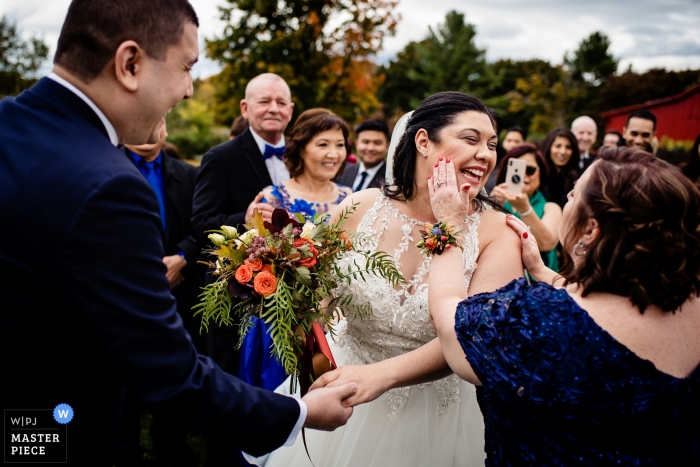 Picture of a bride having lipstick wiped off her cheek by a top Charlotte, Vermont wedding photographer Picture of a bride having lipstick wiped off her cheek by a top Charlotte, Vermont wedding photographer