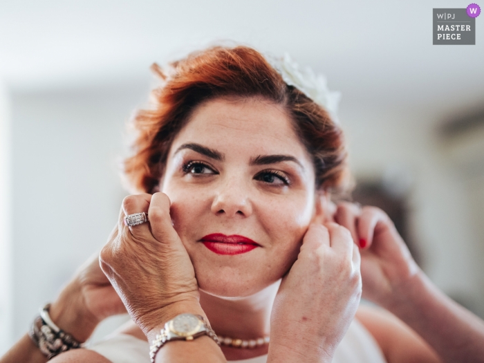 Photo by: <a href="https://www.wpja.com/contests/2018-v16/best-wedding-photographers/2329116">Daniel Monteiro - Porto </a> Wedding photojournalism Image from Porto a bride receiving help as she puts on her earrings
