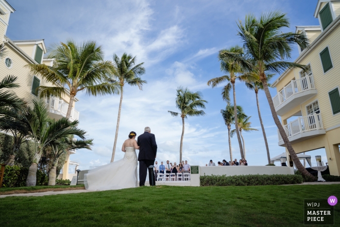 Photo: <a href="https://www.wpja.com/contests/2018-v16/best-wedding-photographers/2329731"> Julie Ambos - Key West en Floride </a> Plus au sud sur la plage, photographie de mariage à Key West de la mariée et de son père marchant dans la cérémonie en plein air sous des palmiers.