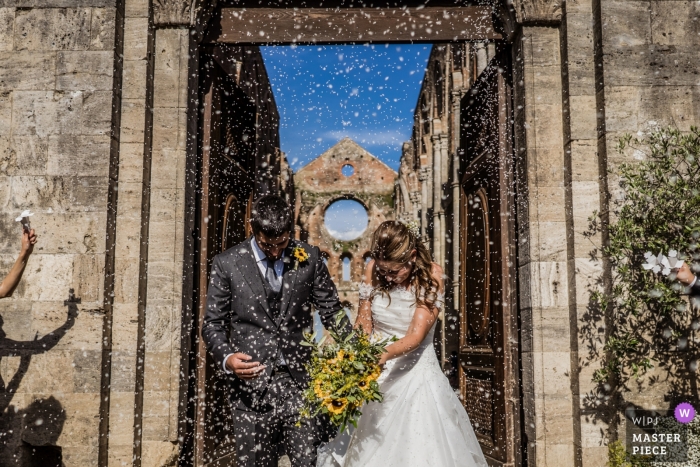 Zdjęcie: <a href="https://www.wpja.com/contests/2018-v17/best-wedding-photographers/2332361"> Andrea Sampoli - Siena </a> Włochy Fotograf ślubny zdobył pannę młodą i pod konfetti niebo - San Galgano Abbey, Siena