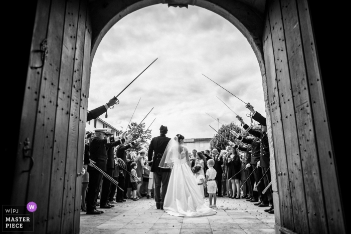 Foto por: <a href="https://www.wpja.com/contests/2018-v17/best-wedding-photographers/2335436"> Florent Fauqueux - La Rochelle </a> La novia y el novio son recibidos por un seto de honor de la medicina militar después de su ceremonia religiosa - Fotografía de bodas en La Rochelle - La salida de la iglesia de los recién casados bajo una guardia de honor