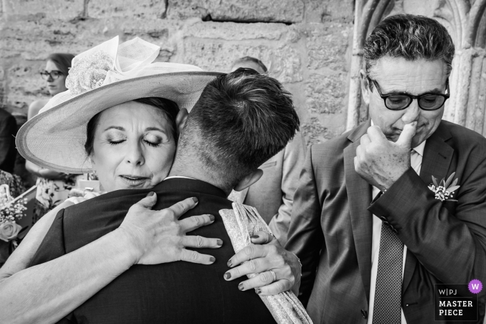 Photo by: <a href="https://www.wpja.com/contests/2018-v17/best-wedding-photographers/2336526">William Lambelet - Montpellier </a> Montpellier, FRANCE wedding photo of a groom hugging a guest | wedding photograph in black-and-white