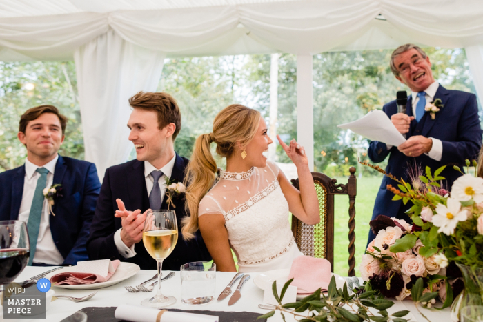 Tipperary, Ierland Huwelijksshoot met een bruid en haar vader die blikken en gebaren uitwisselt tijdens zijn toespraak bij de receptie