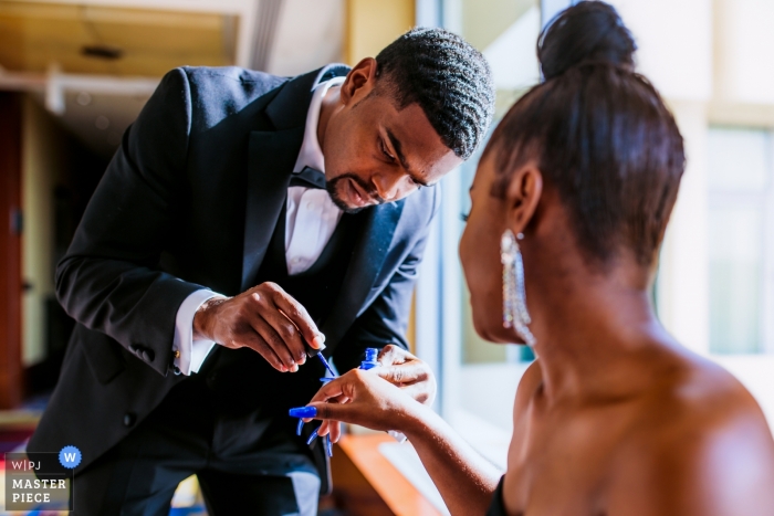 Photo d'un marié peignant les ongles des mariées par un photographe de mariage de Fredericksburg, VA