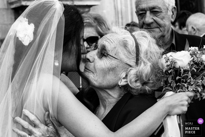 Foto von: <a href="https://www.wpja.com/contests/2018-v17/best-wedding-photographers/2341501"> Salvo Moroni - Viagrande Catania </a> Sicilia-Hochzeitsfotografie einer Braut, die eine ältere Frau umarmt, während sie ihren Blumenstrauß der Blumen hält