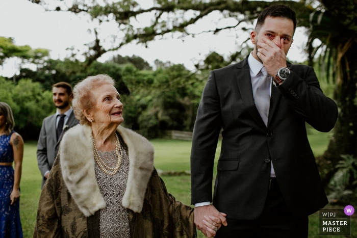 Zdjęcie: <a href="https://www.wpja.com/contests/2018-v17/best-wedding-photographers/2342861"> Renan Radici - Porto Alegre Rio Grande do Sul </a> Zdjęcie ślubne pana młodego przejęte przez emocje z Rio Grande do Sul, gdy zakrywa twarz dłonią fotografia ślubna w alto da capela