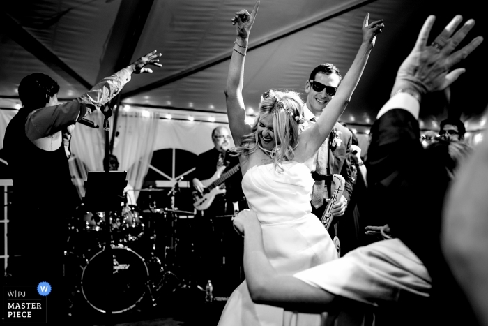 Photo by: <a href="https://www.wpja.com/contests/2018-v18/best-wedding-photographers/2351306">Trent Gillespie - Silverthorne Colorado</a> Bride getting down on stage during her wedding reception. | Camp Hale Wedding Photography