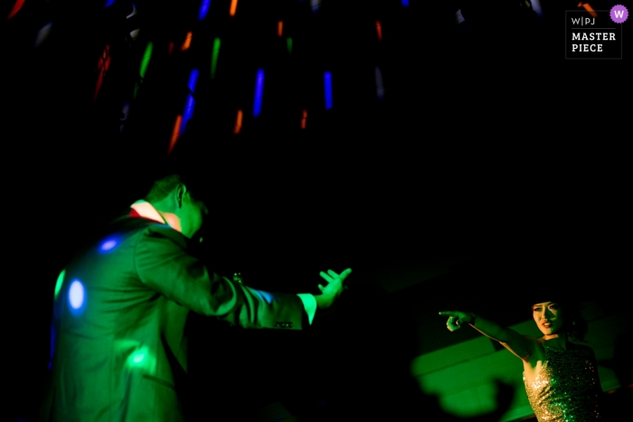 Foto por: <a href="https://www.wpja.com/contests/2018-v18/best-wedding-photographers/2353751"> Siliang Wang - San Jose California </a> Imagen de una pareja bailando en recepción bajo luces verdes de DJ por un fotógrafo de bodas de San José