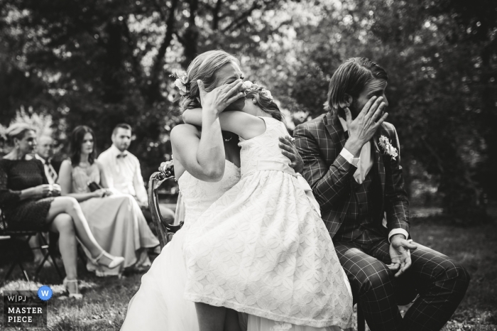 Foto di nozze di Viersen, Germania della sposa e dello sposo che puliscono gli strappi durante la cerimonia all'aperto.