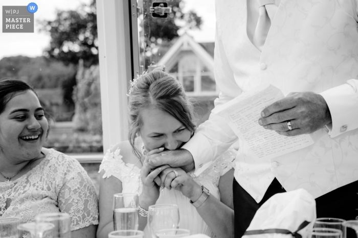 Photo by: <a href="https://www.wpja.com/contests/2018-v18/best-wedding-photographers/2356271">Clive Blair - Birmingham West Midlands</a> The Hibernia, Hobbs Of Henley Boat Hire wedding photograph of the bride kissing the grooms hand during his speech.