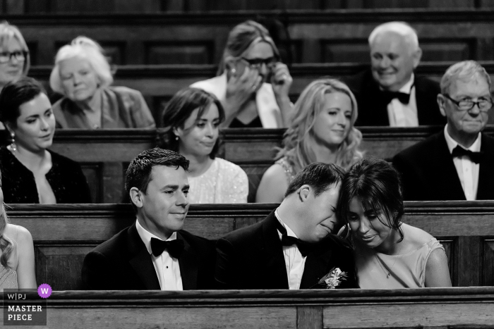 Photo by: <a href="https://www.wpja.com/contests/2018-v18/best-wedding-photographers/2358406">Shane O'Neill - Waterford Waterford</a> Wedding photojournalism at Trinity Chapel, Dublin, Ireland of emotional guests in the pews