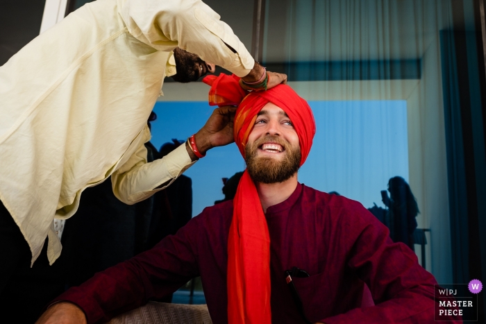 Foto por: <a href="https://www.wpja.com/contests/2018-v18/best-wedding-photographers/2358956"> Bernie Richardson - Dubai </a> Foto de la boda de Waldorf Astoria Dubai del novio que consigue el headwear formado.