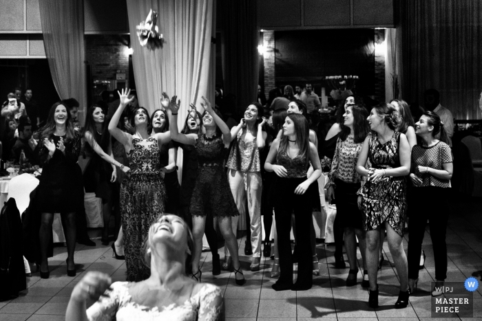 Photo: <a href="https://www.wpja.com/contests/2018-v18/best-wedding-photographers/2359316"> Elena Haralabaki - Nea Ionia Attica </a> Le photojournalisme de mariage dans la salle de réception à Athènes alors que la mariée lance son bouquet aux femmes célibataires