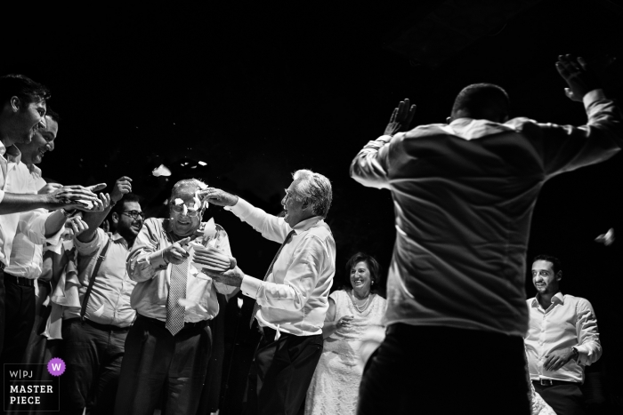 Photo: <a href="https://www.wpja.com/contests/2018-v18/best-wedding-photographers/2359326"> Elena Haralabaki - Nea Ionia Attica </a> Photographie documentaire de mariage à Athènes - Des invités cassent des assiettes sur la tête d'un homme sur la piste de danse