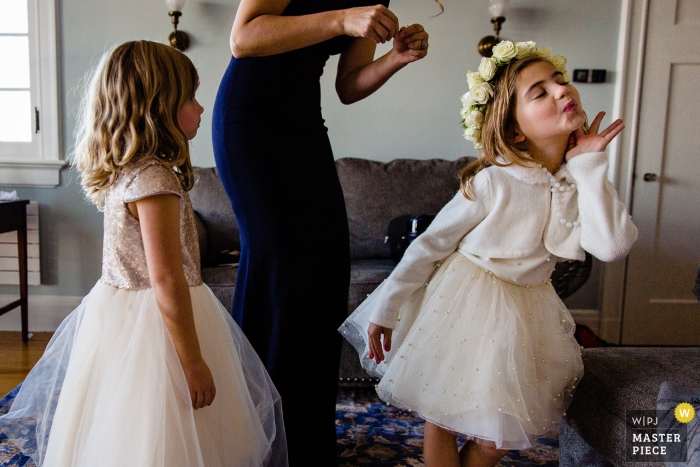 Foto por: <a href="https://www.wpja.com/contests/2018-v18/best-wedding-photographers/2359816"> Kate Crabtree - Bangor Maine </a> Imagen de fotoperiodismo de bodas de muchachas de las flores divirtiéndose en Blue Hill, Maine