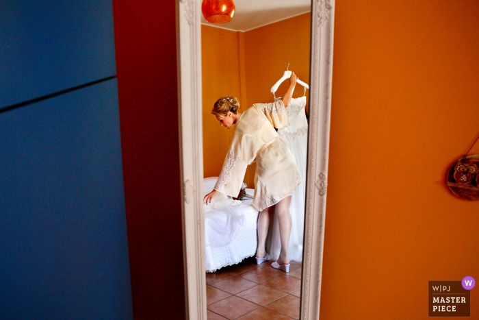 Photo by: <a href="https://www.wpja.com/contests/2018-v18/best-wedding-photographers/2360236">Danilo Coluccio - Siderno Reggio Calabria</a> Reggio Calabria documentary wedding photo of bride holding her dress on a hanger