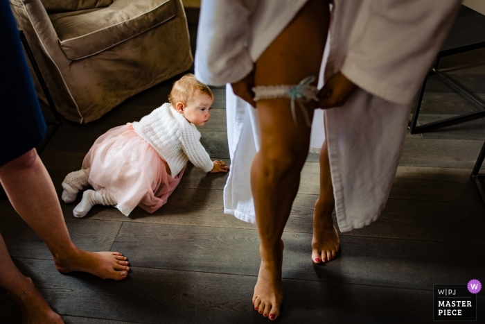 Photo by: <a href="https://www.wpja.com/contests/2018-v19/best-wedding-photographers/2366461">Tobias Löhr - Niddatal Hessen</a> Wedding photojournalism at Hesse with baby girl in dress crawling on the floor by the bride