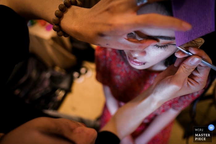 Photo by: <a href="https://www.wpja.com/contests/2018-v19/best-wedding-photographers/2366971">An Le - Ho Chi Minh </a> Ho Chi Minh wedding photography of eye makeup getting applied to bride in Vietnam