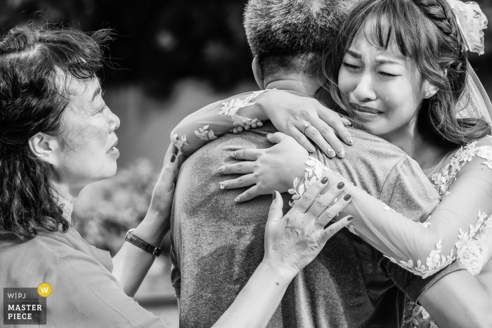 Photo by: <a href="https://www.wpja.com/contests/2018-v19/best-wedding-photographers/2368611">Leon Wong - Hangzhou </a> Phuket, Thailand wedding photograph of a bride hugging her father and crying while mother looks on