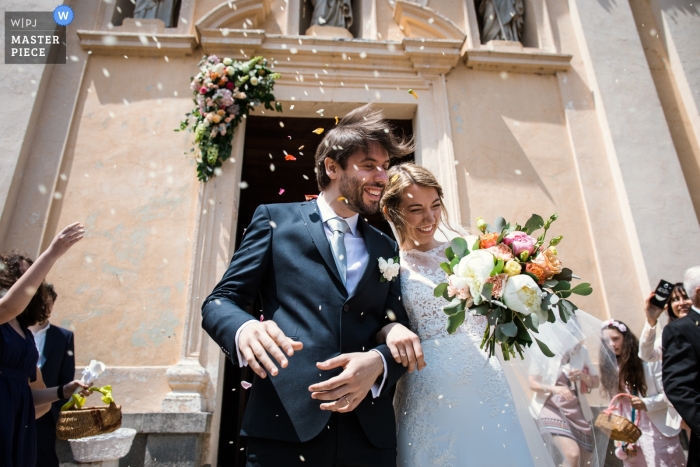 Photo by: <a href="https://www.wpja.com/contests/2018-v19/best-wedding-photographers/2372176">Alessandro Arena - Tradate Varese</a> Varese wedding photojournalism image of a bride and groom leaving church under light confetti shower