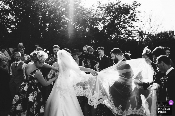 Foto von: <a href="https://www.wpja.com/contests/2018-v19/best-wedding-photographers/2372226"> Rob Dodsworth - Norwich Norfolk </a> Hochzeitsfotojournalismus der Braut und des Bräutigams, die in den Sonnenschein in Southwold, Suffolk gehen