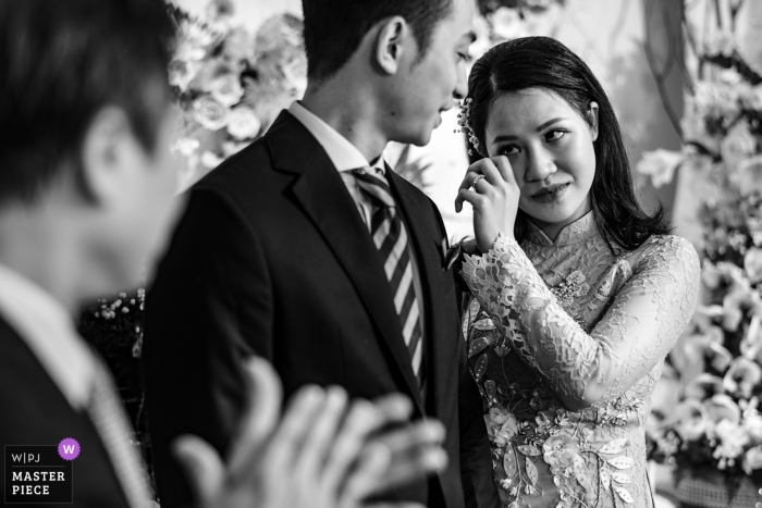 Photo by: <a href="https://www.wpja.com/contests/2018-v19/best-wedding-photographers/2374171">Lucas Tran - Hai Chau Da Nang</a> Da Nang wedding photojournalism image of a bride wiping tears during Vietnam ceremony