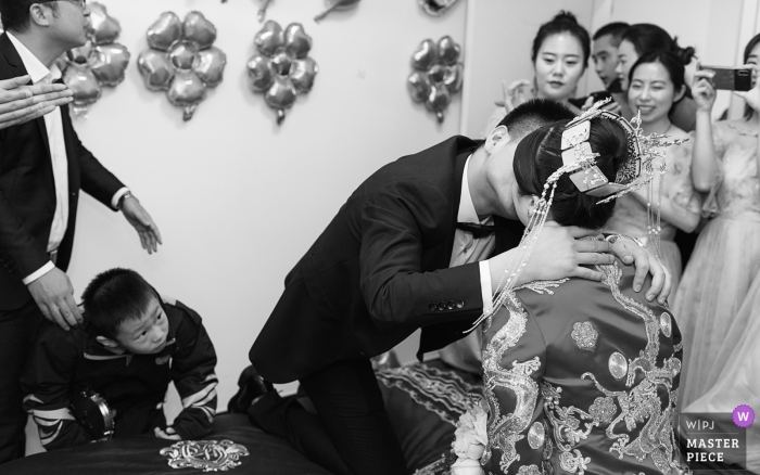 Zdjęcie: <a href="https://www.wpja.com/contests/2018-v19/best-wedding-photographers/2374621"> Lei Zhao - Weinan City </a> Weinan City, prowincja Shaanxi, Chiny fotografia ślubna | mały chłopiec przyglądał się pocałunkowaniu pary młodej i pana młodego, co sprawiło, że wszyscy byli bardzo szczęśliwi.