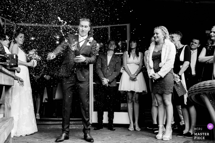 Photo by: <a href="https://www.wpja.com/contests/2018-v19/best-wedding-photographers/2375611">Freek Nagtzaam - 's-Hertogenbosch Noord Brabant</a> tilburg wedding photo shoot of groom cutting off bottle top at reception