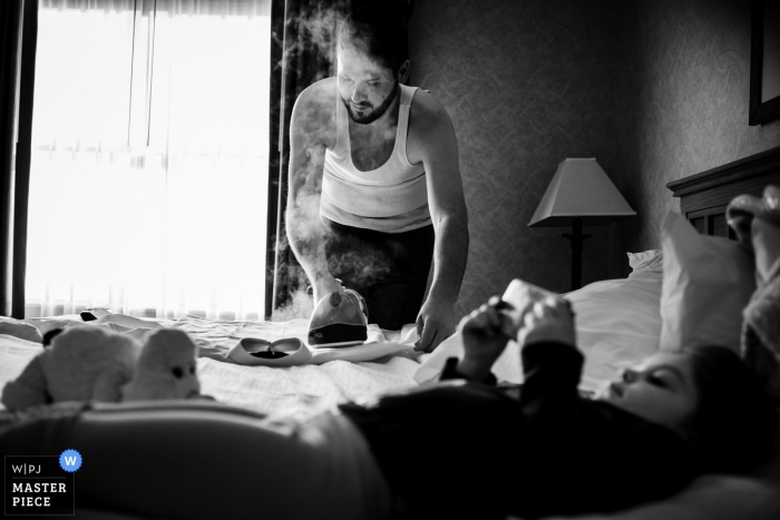 Foto: <a href="https://www.wpja.com/contests/2018-v19/best-wedding-photographers/2377181"> Jacob Hannah - Lincoln Vermont </a> Dokumentarische Hochzeitsfotografie des Bräutigams, der sein Hemd in Omaha, NE bügelt und dämpft
