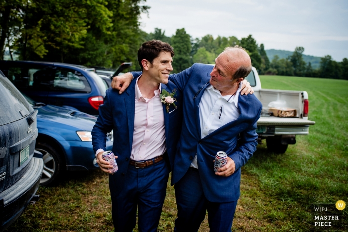 imagem de um noivo de Burlington, Vermont, caminhando e conversando com um amigo em seu casamento ao ar livre