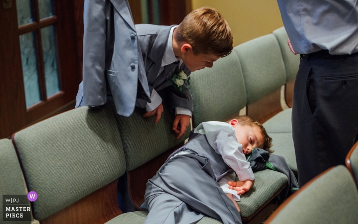 Photo by: <a href="https://www.wpja.com/contests/2018-v19/best-wedding-photographers/2377676">Andrea Bibeault - Omaha Nebraska</a> Omaha Wedding Photograph of a ring bearer sleeping during the ceremony