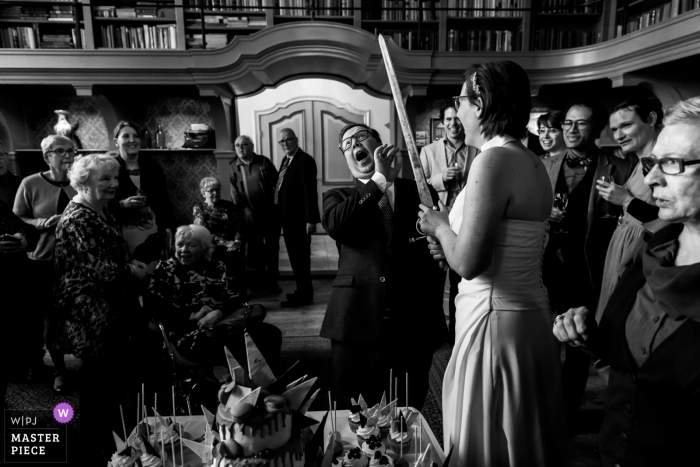 Photo by: <a href="https://www.wpja.com/contests/2018-v19/best-wedding-photographers/2378686">Isabelle Hattink - Rotterdam Zuid Holland</a> Wedding photo shoot in Tiel-Holland of cake cutting couple with huge sword