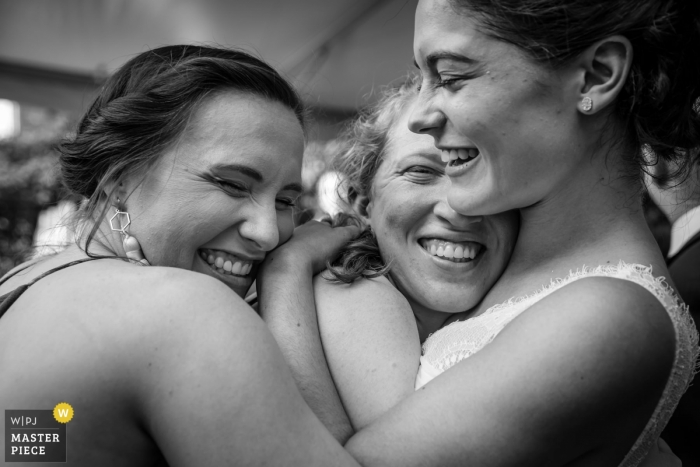 Photo by: <a href="https://www.wpja.com/contests/2018-v19/best-wedding-photographers/2379456">Danette Pascarella - Clinton New Jersey</a> New Jersey wedding photojournalism image of a bride getting hugged by friends