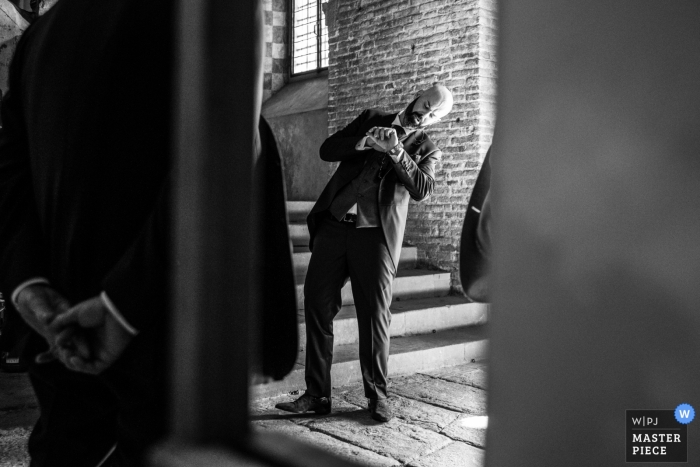 toscana trouwfoto van het controleren van de tijd op een horloge in de kerk | voordat de ceremonie begint