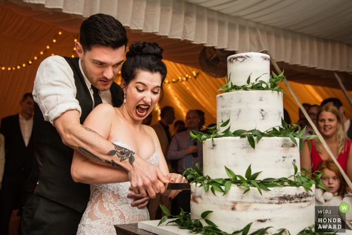 Photo by: <a href="https://www.wpja.com/contests/2018-v20-photography-competition/best-wedding-photographers/2390396">Todd Laffler - High Bridge New Jersey</a> Crossed Keys Inn, New Jersey wedding photojournalism image of a couple cutting their cake