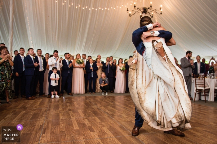 Photo by: <a href="https://www.wpja.com/contests/2018-v20-photography-competition/best-wedding-photographers/2390401">Todd Laffler - High Bridge New Jersey</a> Bride with a really dirty wedding dress getting lifted up by the groom on the dance floor inside a tented reception | Crossed Keys Inn | New Jersey Wedding Photography
