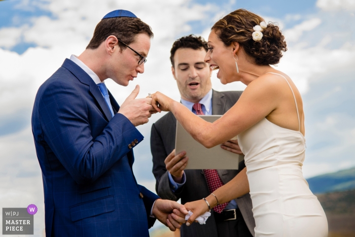 Fotografía de boda en Colorado del novio a punto de besar la mano de la novia durante la ceremonia