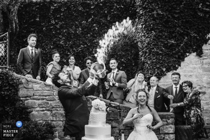 Photo: <a href="https://www.wpja.com/contests/2018-v20/best-wedding-photographers/2391486"> Samuele Ciaffoni - Ancône Ancône </a> Marches photo de la réception de mariage des jeunes mariés sur le gâteau avec les invités du mariage