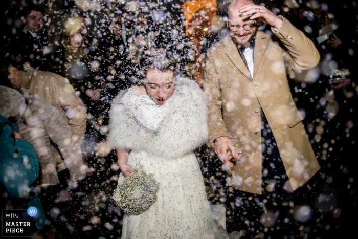 Fotografia di nozze della sposa e dello sposo che lasciano nella doccia della neve | Momenti del giorno delle nozze catturati in Oise