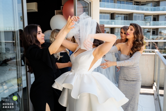 Foto di nozze documentaria di Melbourne della sposa colta nel velo - Mettendo il velo, la sposa si è aggrovigliata.