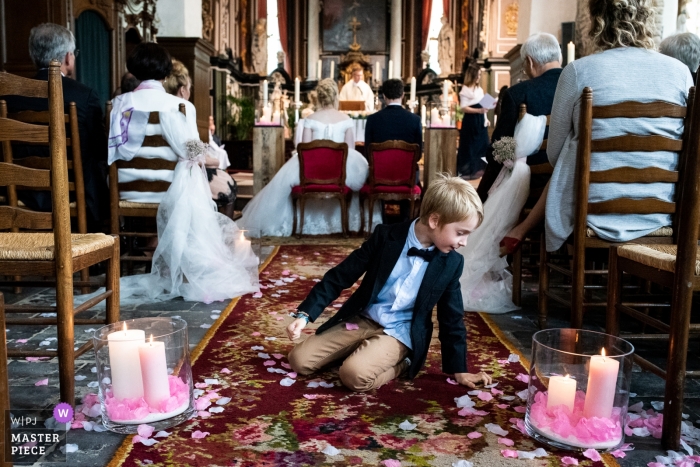 Photo by: <a href="https://www.wpja.com/contests/2018-v20/best-wedding-photographers/2398191">Ruth Wytinck - Landegem Oost-Vlaanderen</a> Church wedding photography of boy playing in aisle in East Flanders | during the ceremony