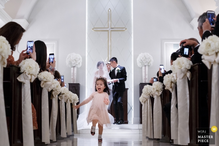Photo by: <a href="https://www.wpja.com/contests/2018-v20/best-wedding-photographers/2400721">Vincent Mu - De Zhou </a> wedding photograph of little girl running out the aisle from Shandong, China | wedding ceremony
