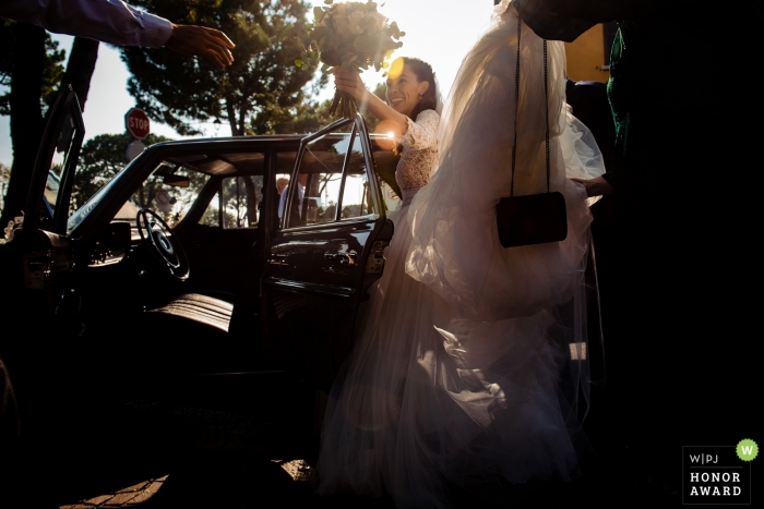 Sesión de boda con novia de Italia saliendo del auto con ramo - sirmione lake garda italy